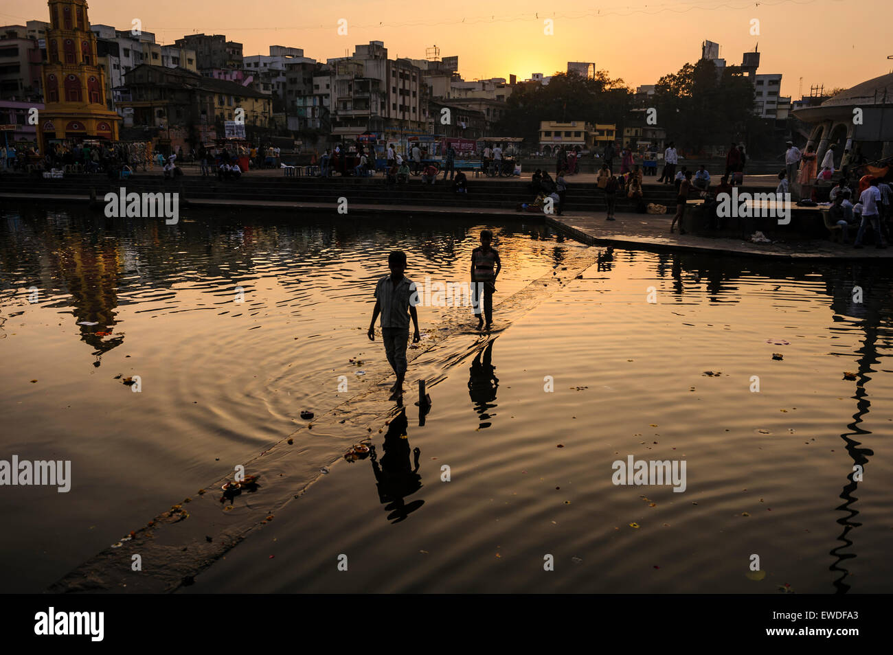 Boys crossing Godavari river at sunset, Nashik, Maharashtra, India. Stock Photo