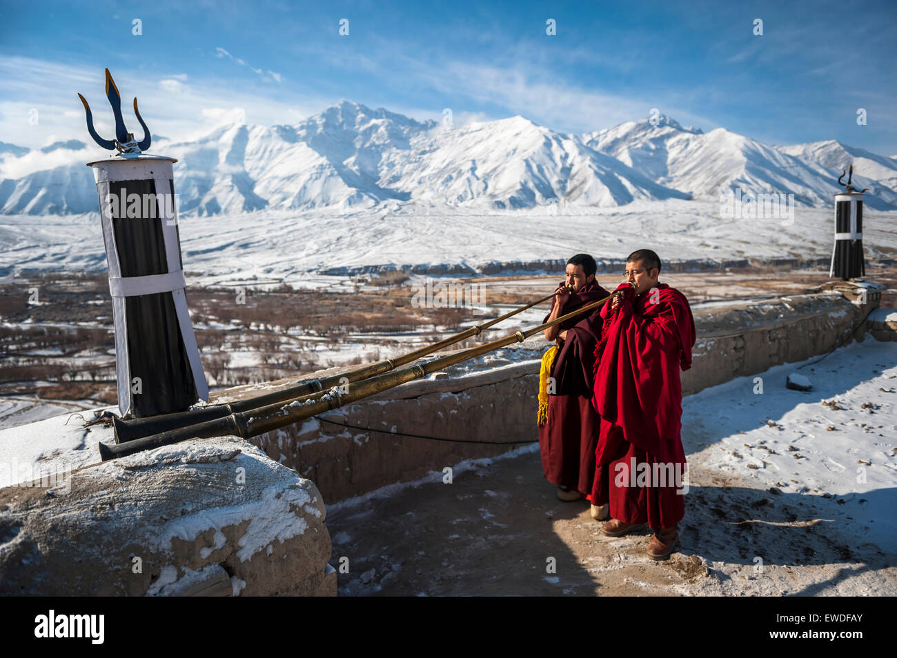 Two monks playing Tibetan trumpets (dungchen) on a roof of Spitok Monastery, Ladakh, India. Stock Photo