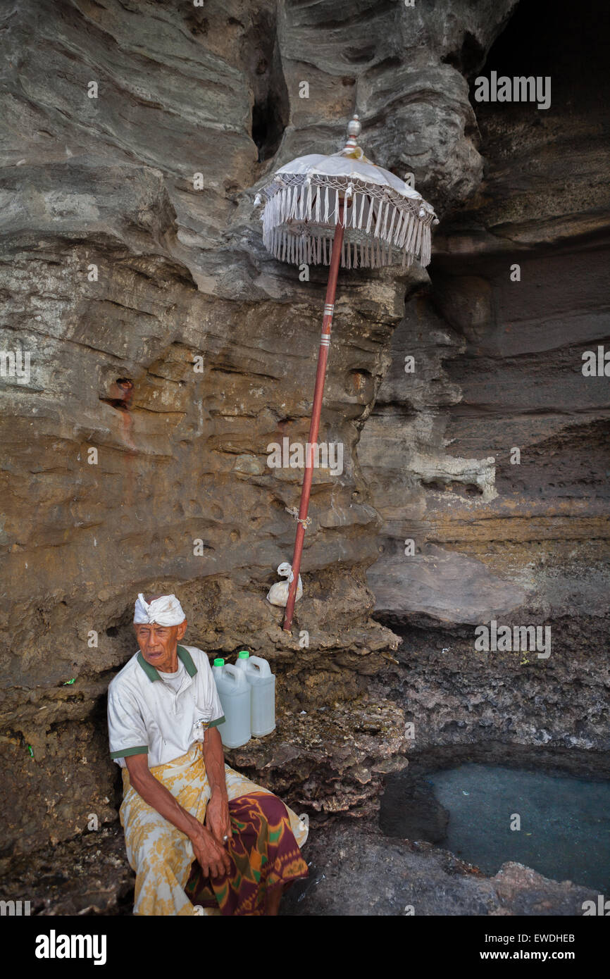 Portrait of a man who is guarding a sacred spring located at the foot of a rocky hill where Tanah Lot temple is built in Tanah Lot, Bali, Indonesia. Stock Photo