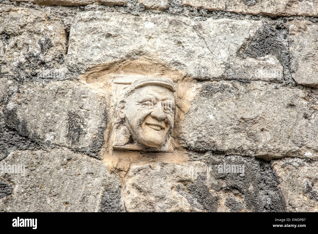 Hand carved stone face in Bath Stone on the wall in Walcot Street in Bath one of more than 30 grotesques on display Stock Photo