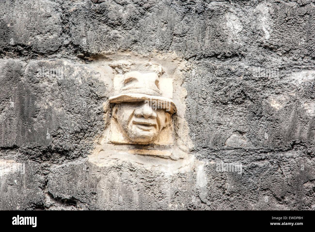 Stone face hand carved in Bath Stone in the wall of Walcot Street in Bath and one of more than 30 grotesques Stock Photo