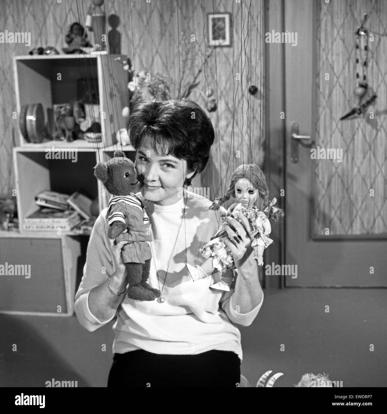 Deutsche Fernsehansagerin und Moderatorin Hilde Nocker erzählt mit den Marionetten Teddy und Puppi eine Sandmännchen Geschichte, Deutschland 1960er Jahre. German TV presenter Hilde Nocker and the puppets Teddy and Puppi present some bedtime stories for children, Germany 1960s. Stock Photo