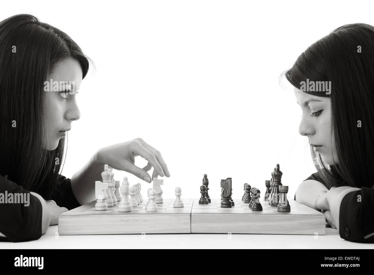 young woman playing chess against herself shot in the studio Stock Photo