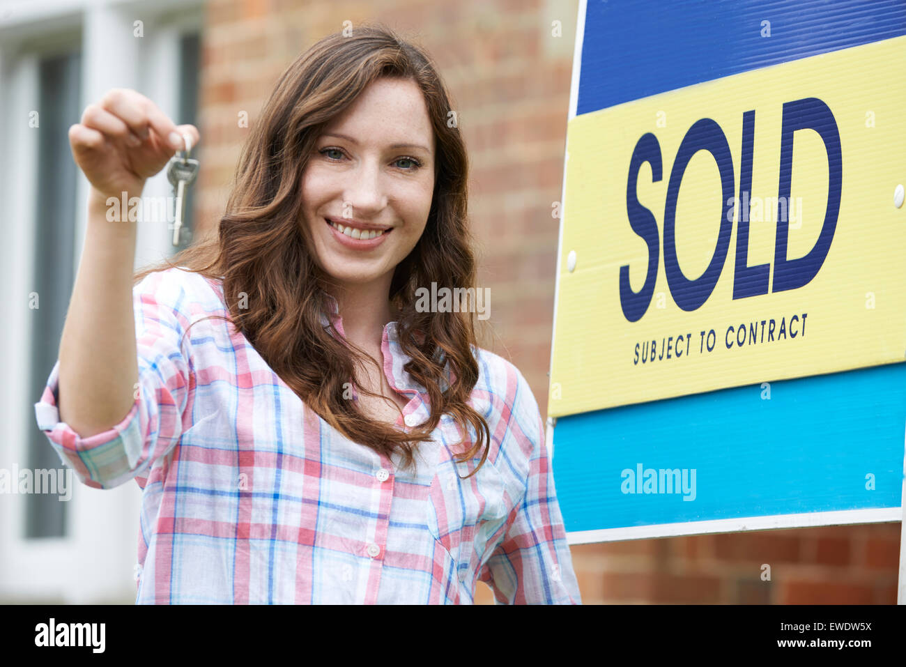Excited Woman Outside New Home Holding Keys Stock Photo - Alamy