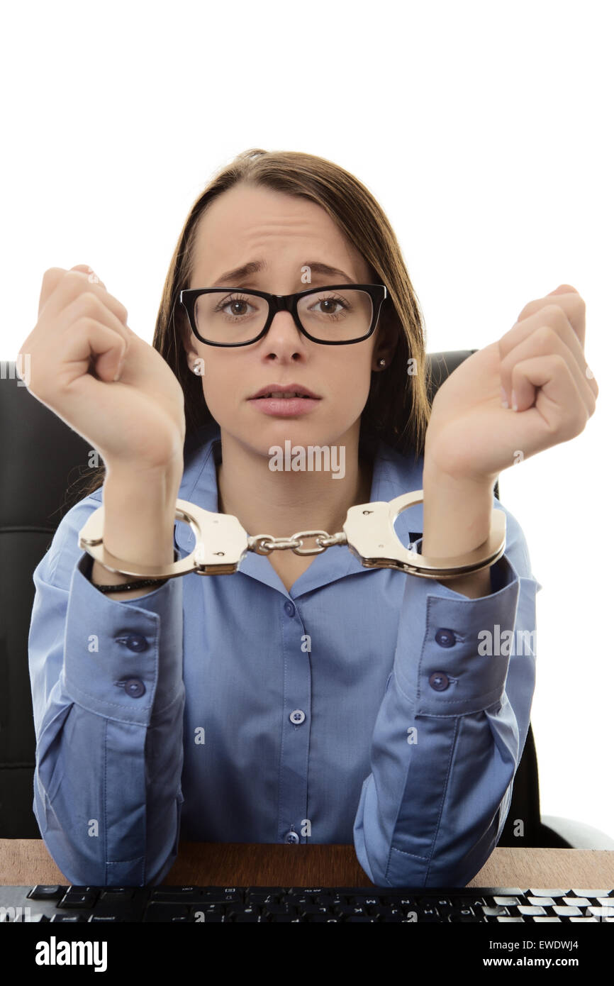 woman sitting at her desk at work with her hands  handcuffed together Stock Photo