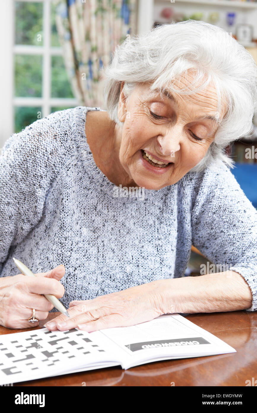 Senior Woman Relaxing With Crossword Puzzle At Home Stock Photo Alamy