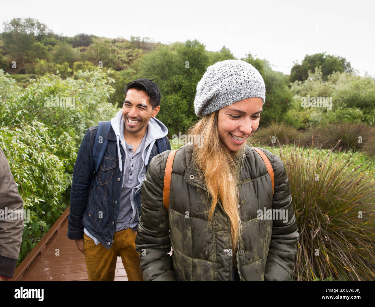 Smiling young woman and man walking in a park Stock Photo