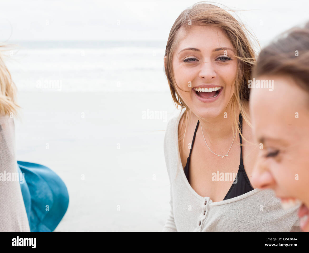 Two smiling young women walking on a beach Stock Photo