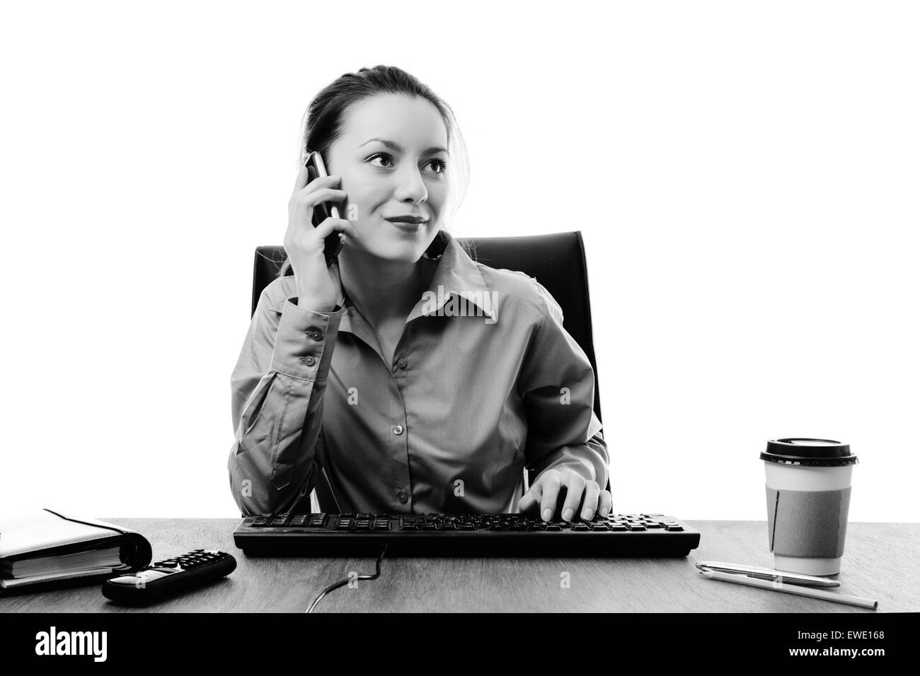 woman working at her desk on a mobile phone Stock Photo