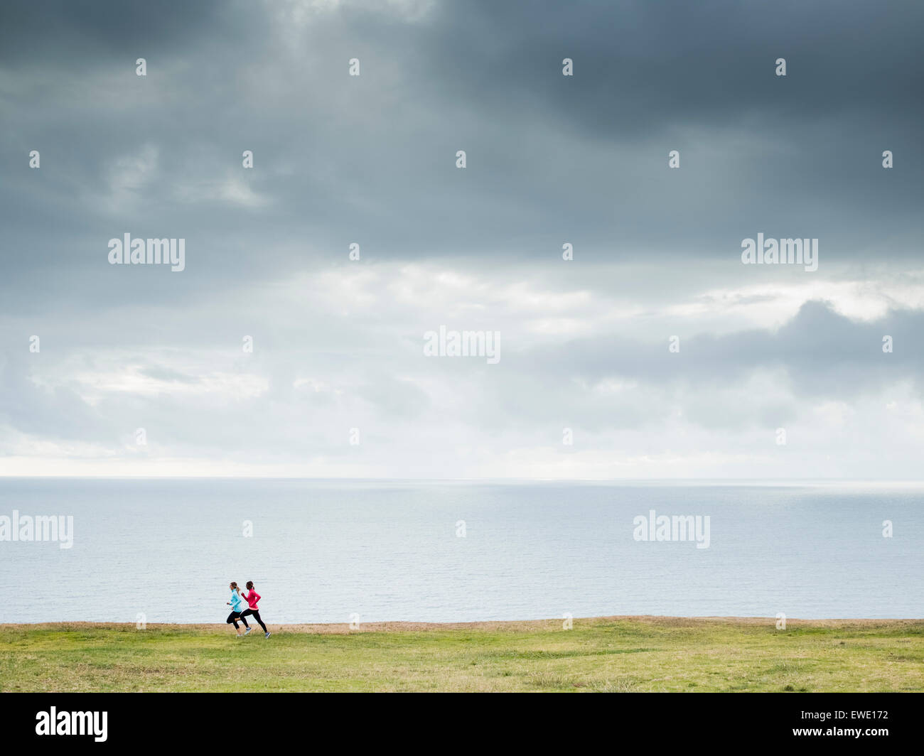 Two women jogging along the coast runners Stock Photo