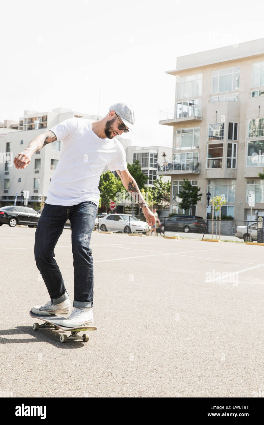 Young man skateboarding in a car park urban city life Stock Photo