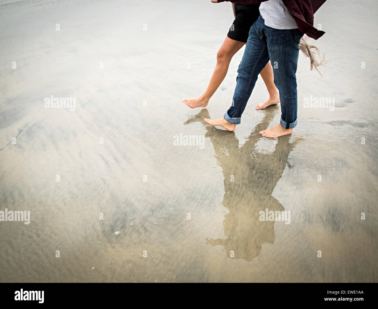 Young man and young woman walking on a beach Stock Photo