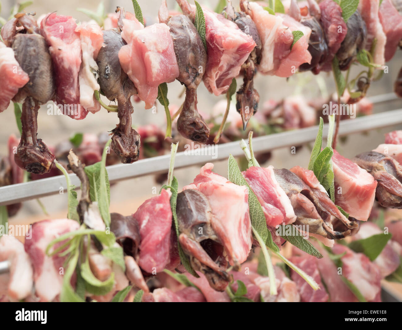 birds on the spit with meat, bacon and sage ready for roasting Stock Photo