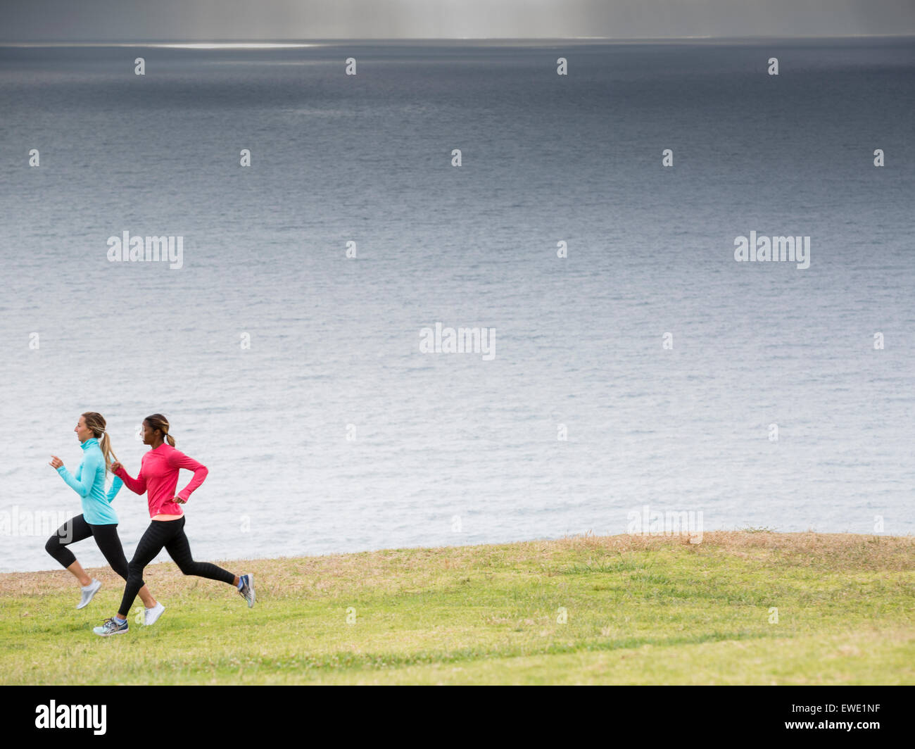 Two women jogging along the coast Stock Photo