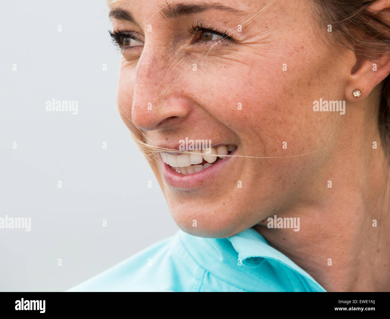 a smiling young woman face looking sideways Stock Photo
