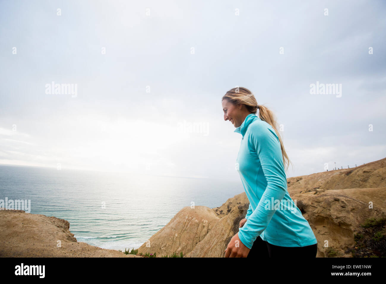 Woman jogging along the coast running on path Stock Photo