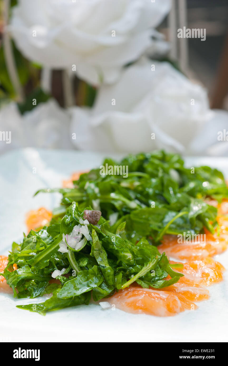 fresh salmon carpaccio sushi sashimi with arugula rocket salad and