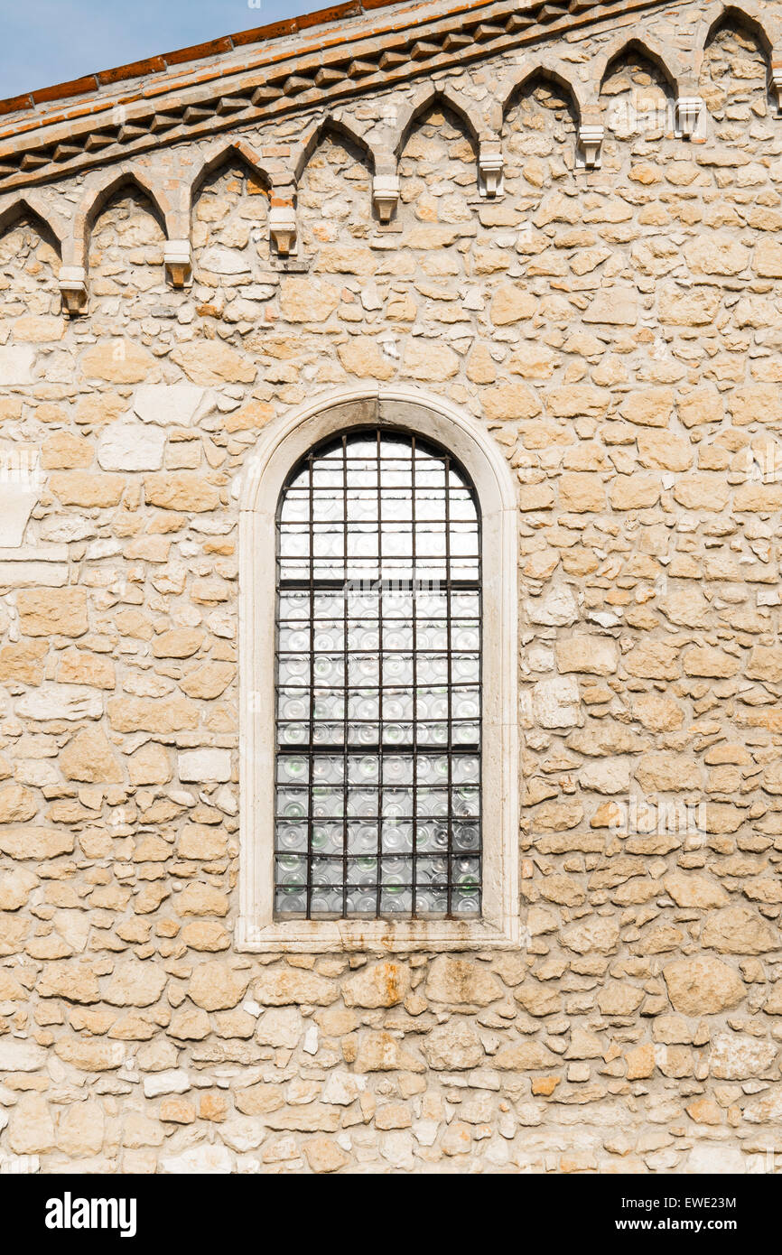 Arched window in the ancient medieval stone wall Stock Photo