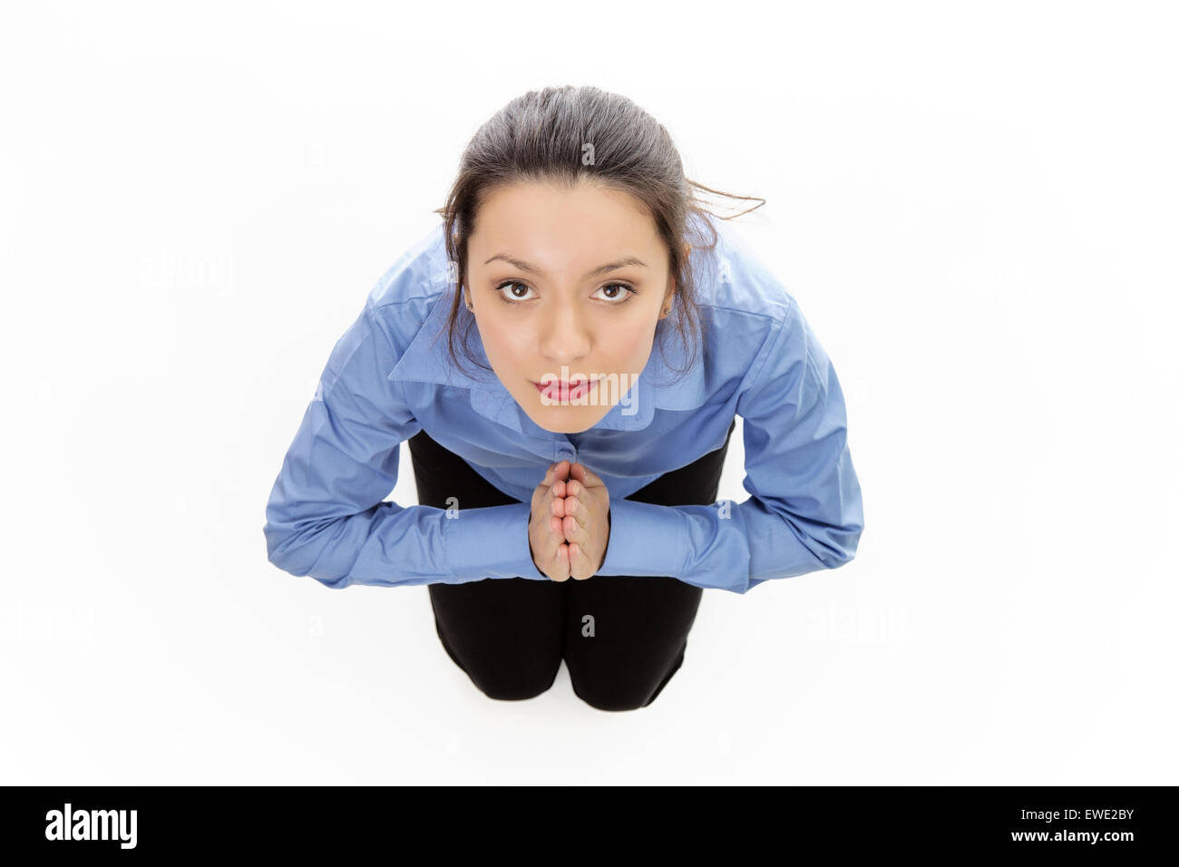 woman praying on her kneels shot from a brids eye view looking down Stock Photo
