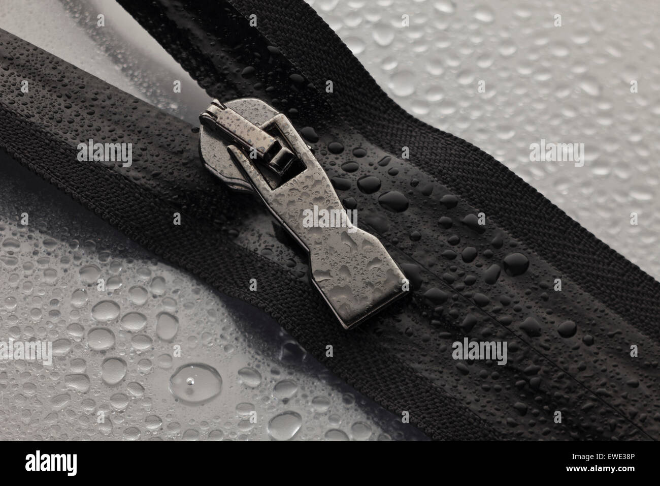 a black zipper opened to a gray surface Stock Photo
