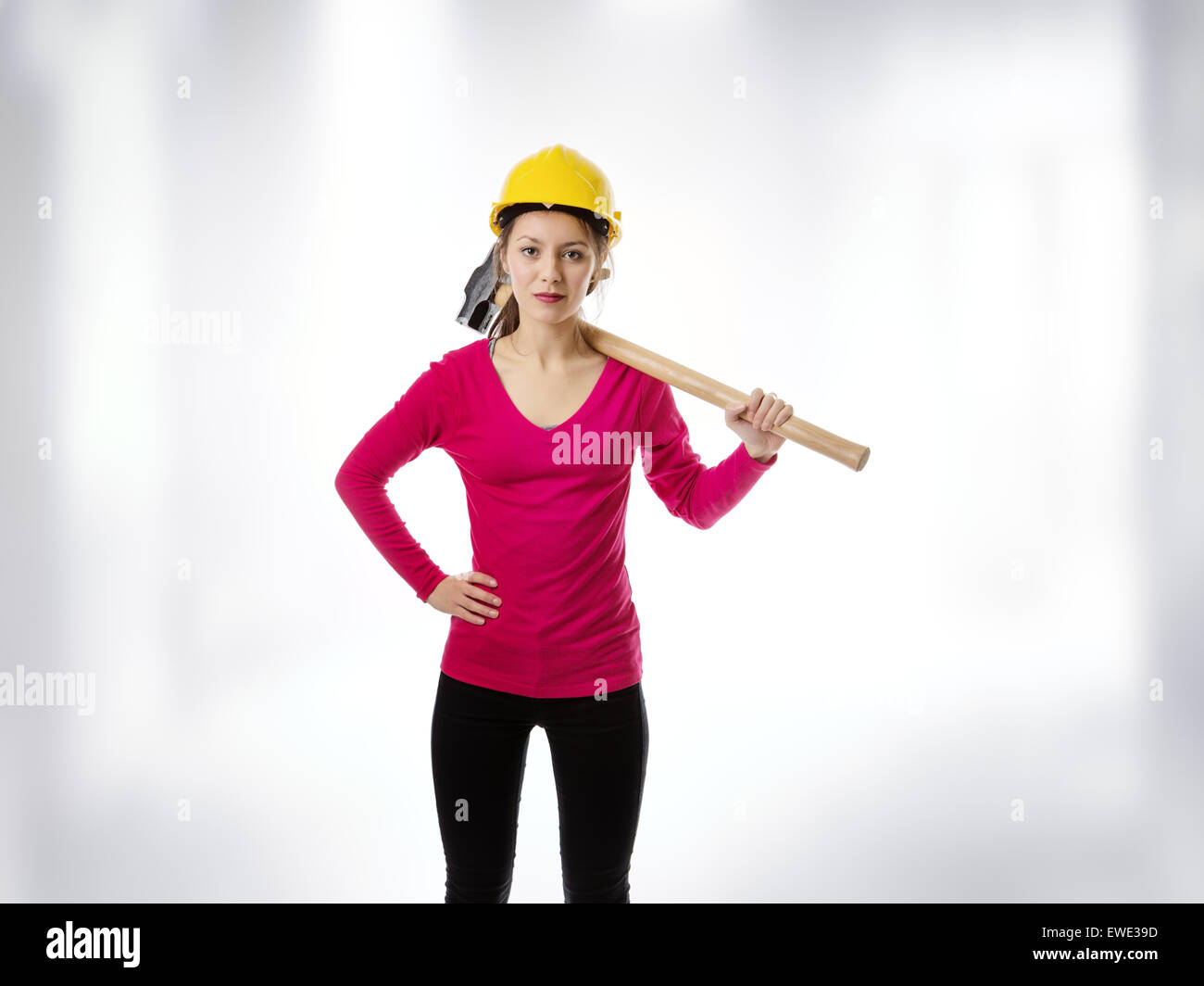 woman holding a sledgehammer and wearing a hard hat about to smash