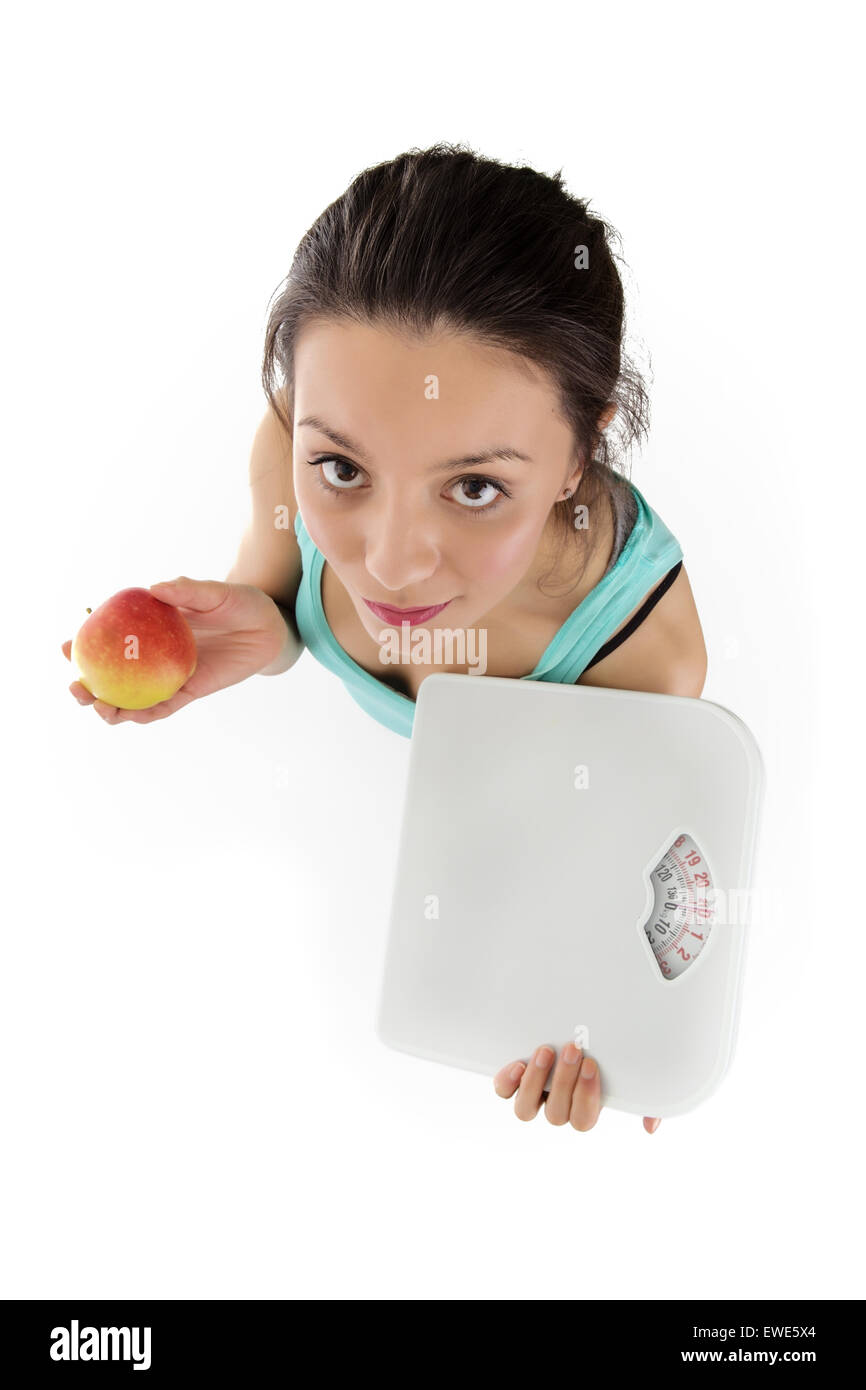 Woman shot from a birds eye view looking down holding scale an an apple Stock Photo