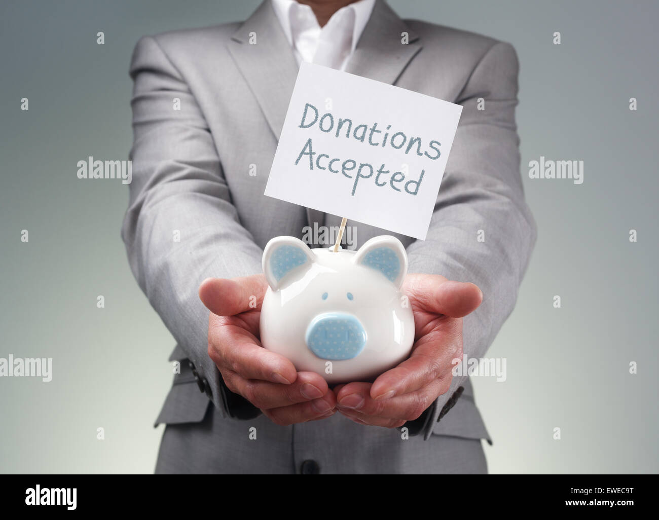 Businessman holding piggy bank donation box for charity fundraising