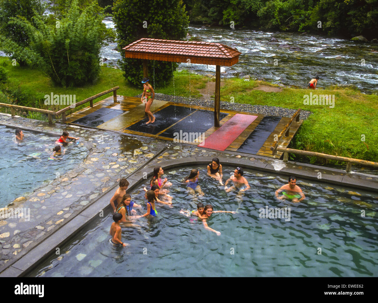 PUCON, CHILE - People in swimming pool at Huife geothermal hot springs by river, in Lake District Stock Photo