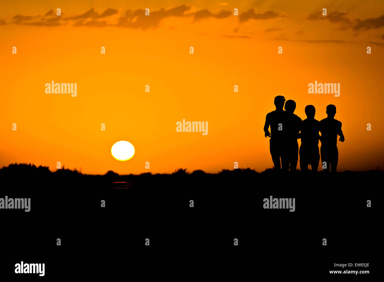 Four people running at sunrise, Ahal Province, Turkmenistan. Stock Photo