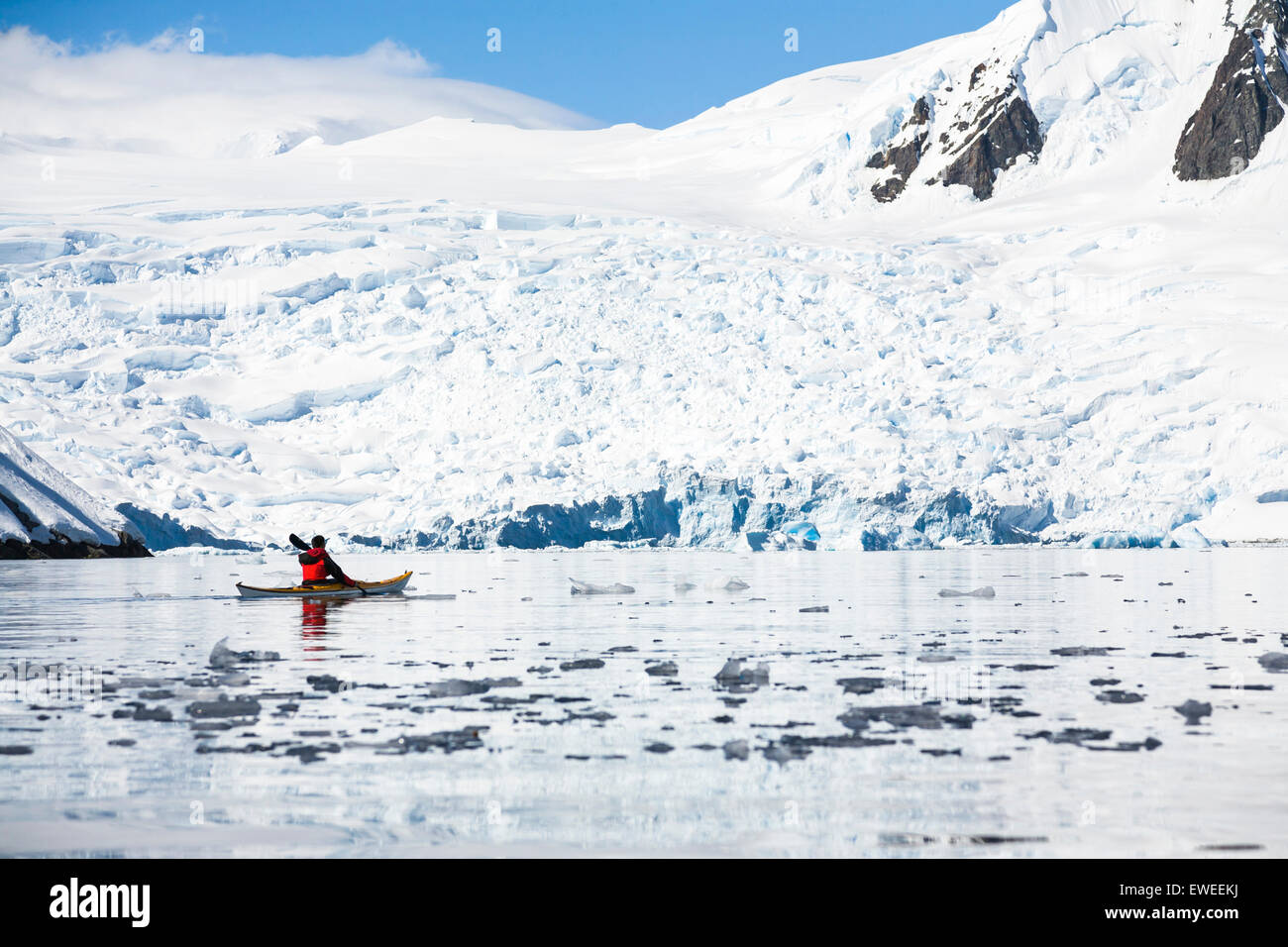 A man is paddling a sea kayak in Graham Passage, Antarctic Peninsula