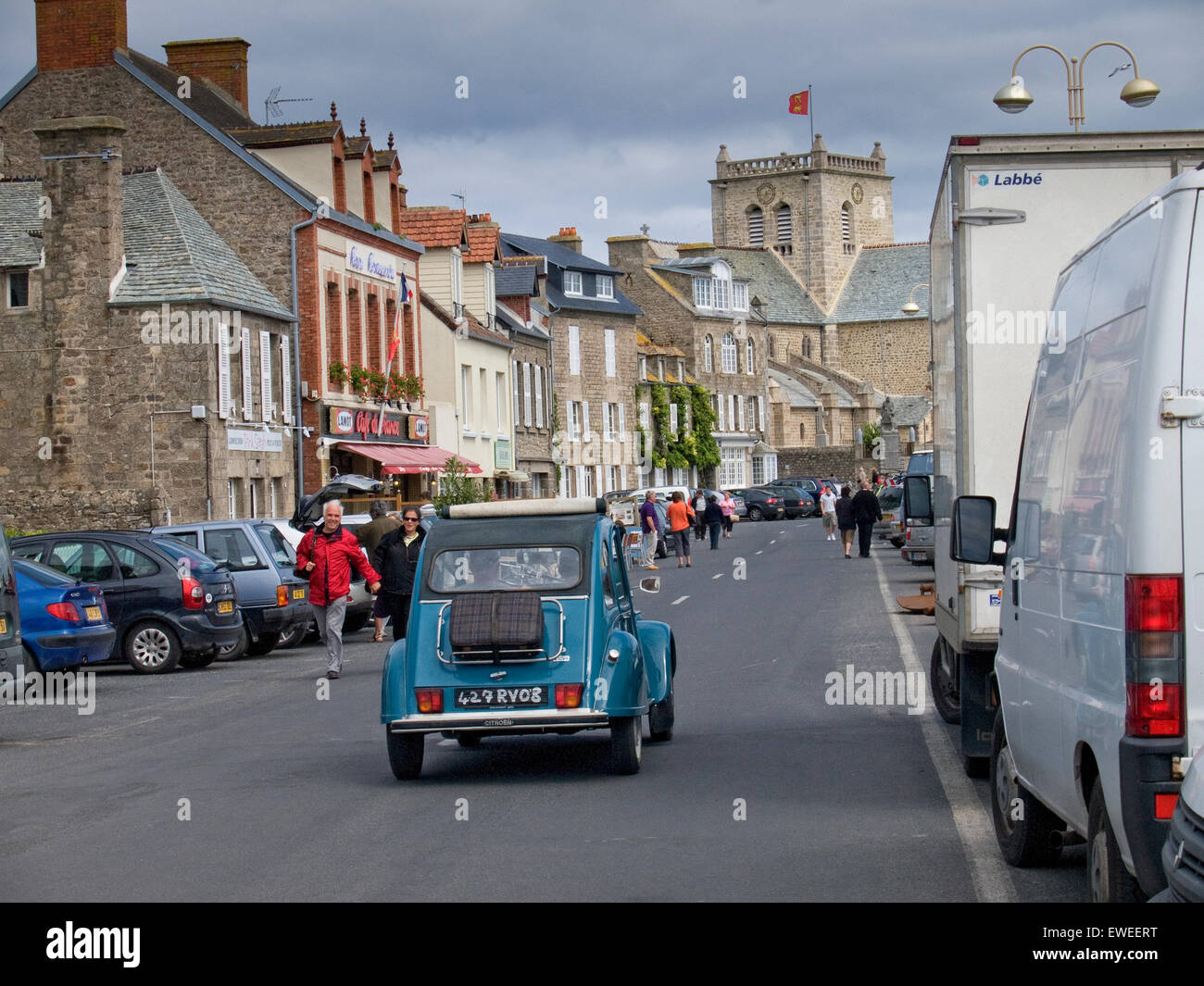 Antique car driving down a street in a village in Normandy. France. Stock Photo