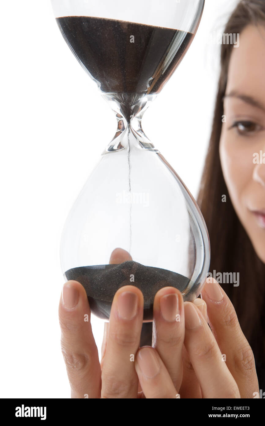 woman holding up a hour glass sand timer watching time slip away Stock Photo