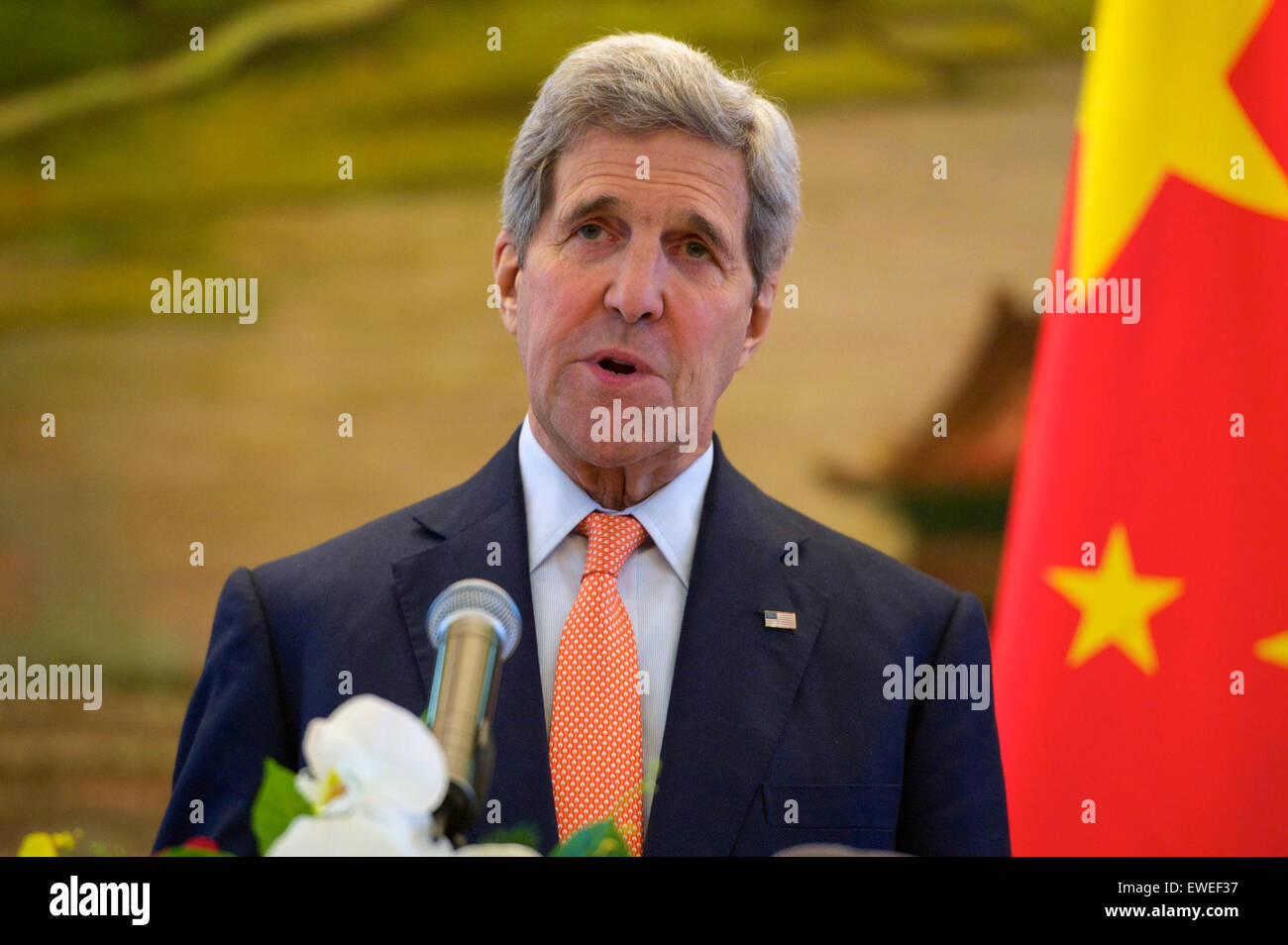 U.S. Secretary of State John Kerry addresses reporters as Chinese Foreign Minister Wang Yi listens at the Ministry of Foreign Affairs in Beijing, China, following a bilateral meeting on May 16, 2015. Stock Photo