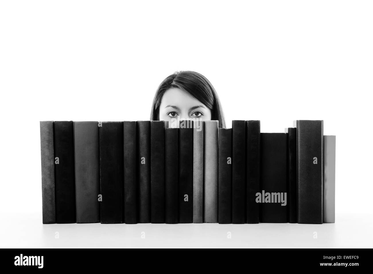 woman looking over books on a bookshelf Stock Photo