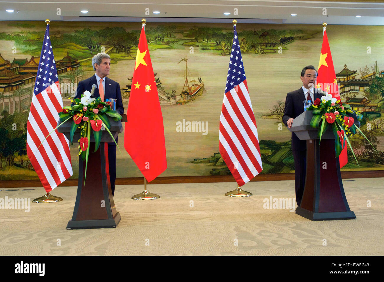 U.S. Secretary of State John Kerry listens as Chinese Foreign Minister Wang Yi addresses reporters at the Ministry of Foreign Affairs in Beijing, China, following a bilateral meeting on May 16, 2015. Stock Photo