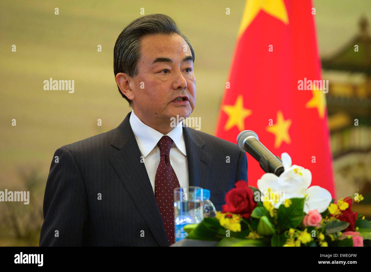Chinese Foreign Minister Wang Yi addresses reporters as U.S. Secretary of State John Kerry listens at the Ministry of Foreign Affairs in Beijing, China, following a bilateral meeting on May 16, 2015. Stock Photo