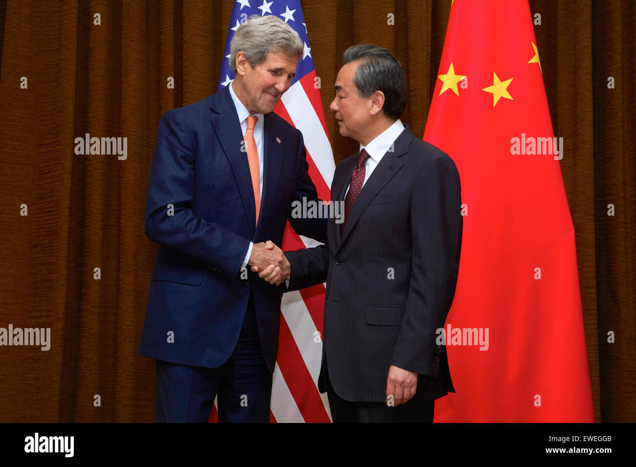 U.S. Secretary of State John Kerry shakes hands with Chinese Foreign Minister Wang Yi at the Ministry of Foreign Affairs in Beijing, China, before a bilateral meeting on May 16, 2015. Stock Photo