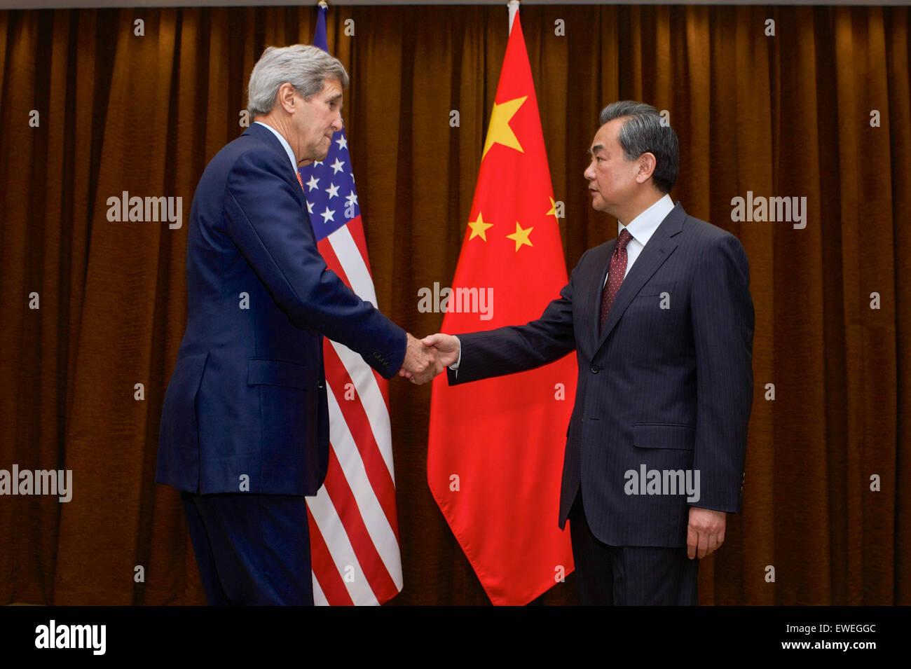 U.S. Secretary of State John Kerry shakes hands with Chinese Foreign Minister Wang Yi at the Ministry of Foreign Affairs in Beijing, China, before a bilateral meeting on May 16, 2015. Stock Photo