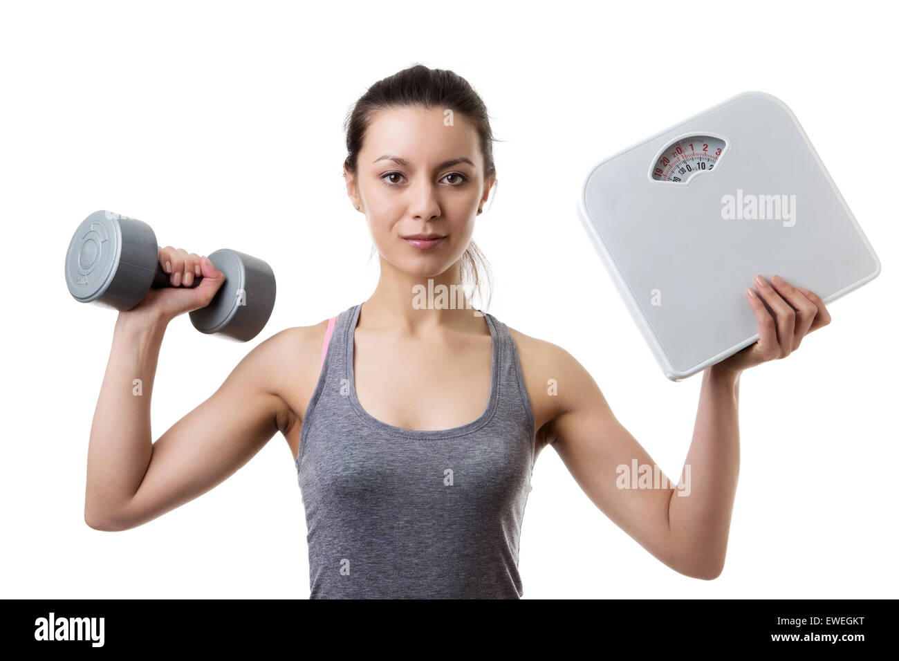 young woman holding scale and a dumbbell up in the air Stock Photo Alamy