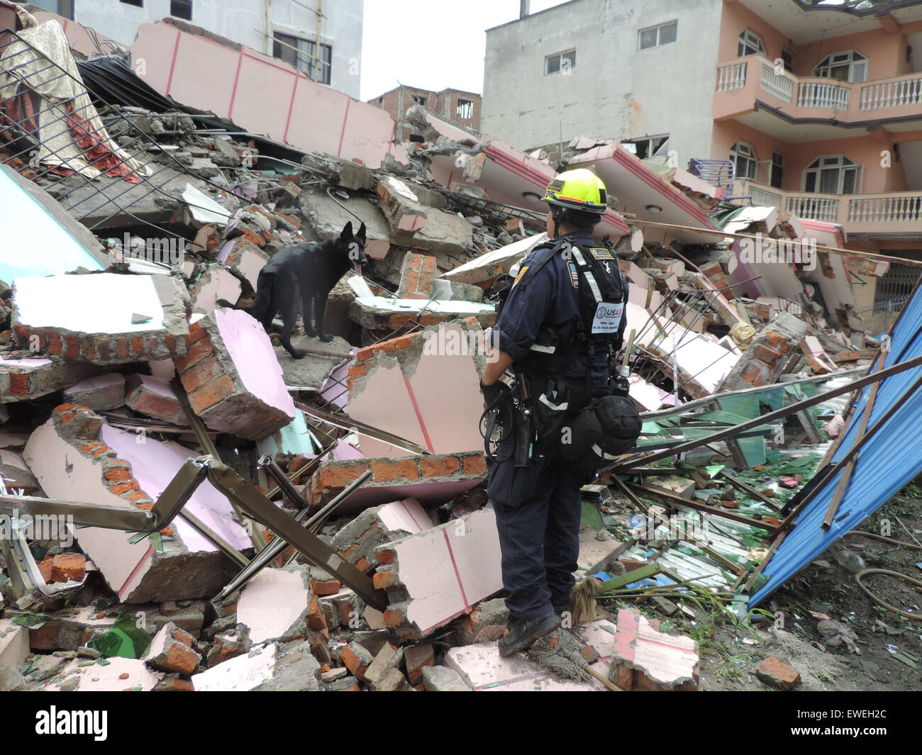 USAID Disaster Assistance Response Team (DART) member and canine with Fairfax, Viginia Urban Search and Rescue, search a collapsed structure in Bhaktapur, Nepal while assisting with U.S. response efforts in the aftermath of the magnitude 7.8 earthquake that struck central Nepal, on April 25th, affecting more than 8 million people and causing widespread damage and destruction. [Fairfax Co Fire &amp; Rescue] Stock Photo