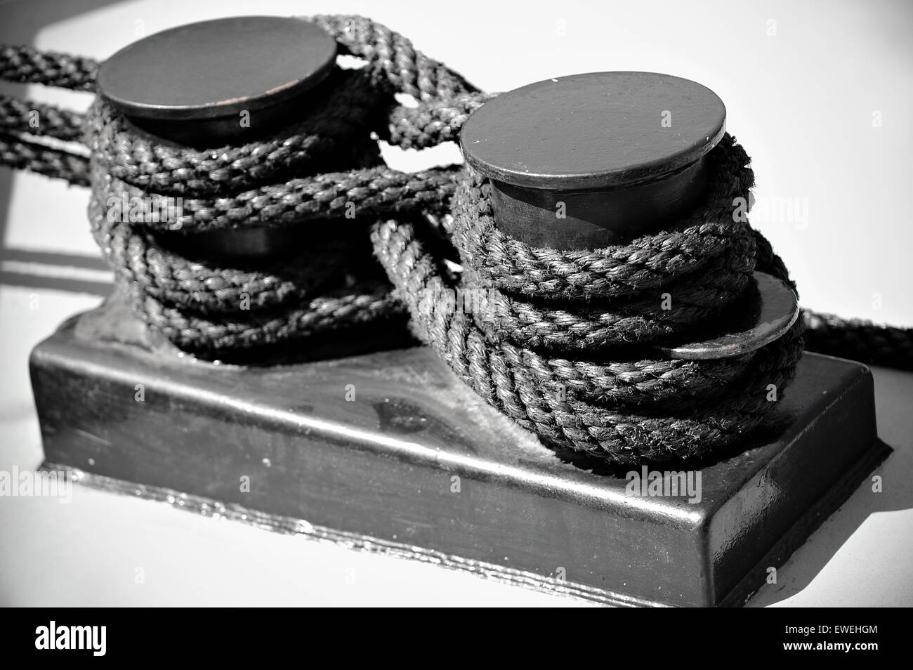 Industrial shot wit nautical black rope tied on a ship as figure eight knot Stock Photo