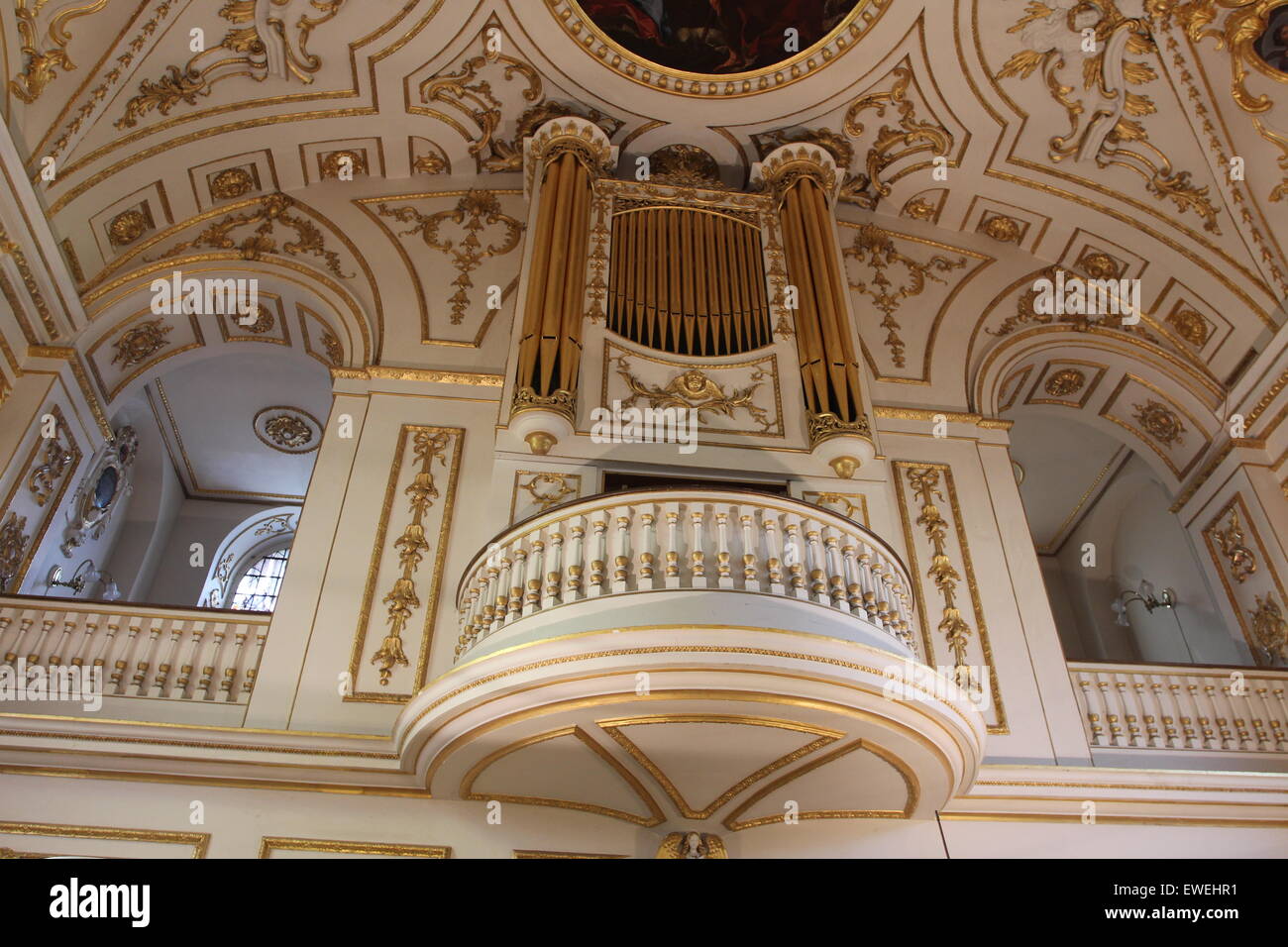 Church Organ gold pipes and Artwork religious painting of the ceiling of the church Stock Photo