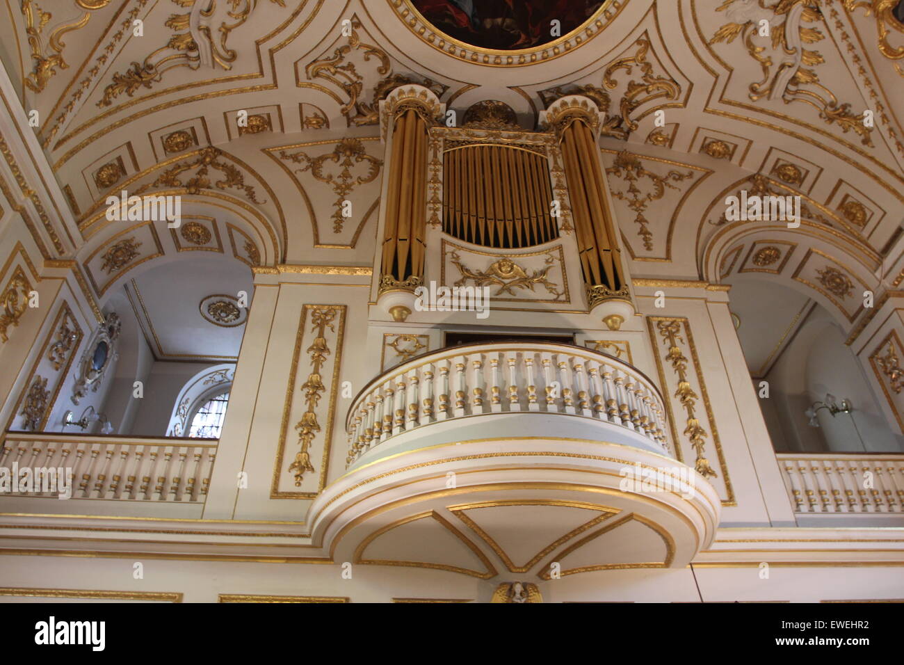 Church Organ gold pipes and Artwork religious painting of the ceiling of the church Stock Photo