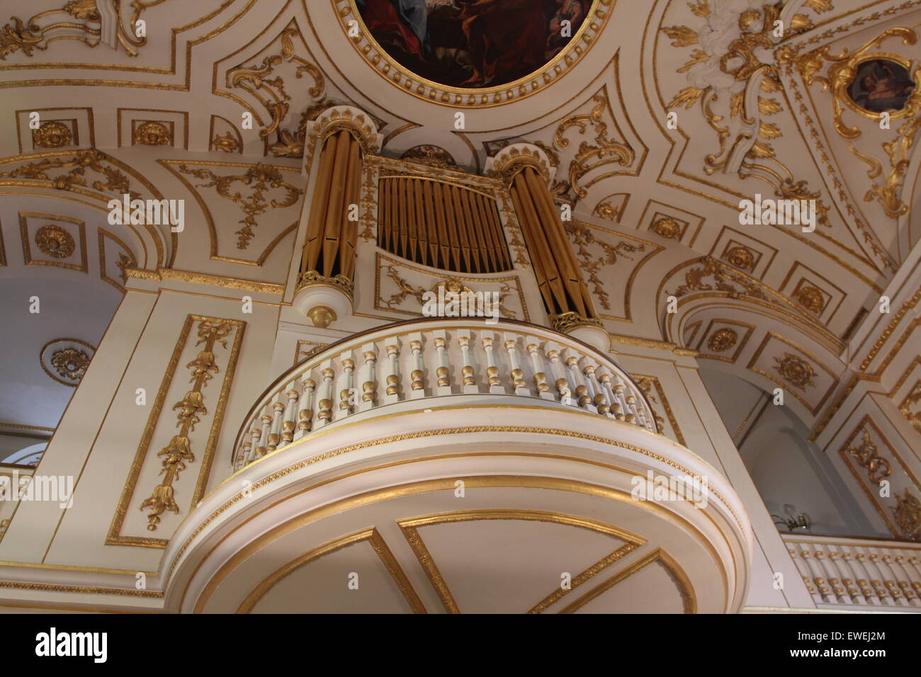 Church Organ gold pipes and Artwork religious painting of the ceiling of the church Stock Photo