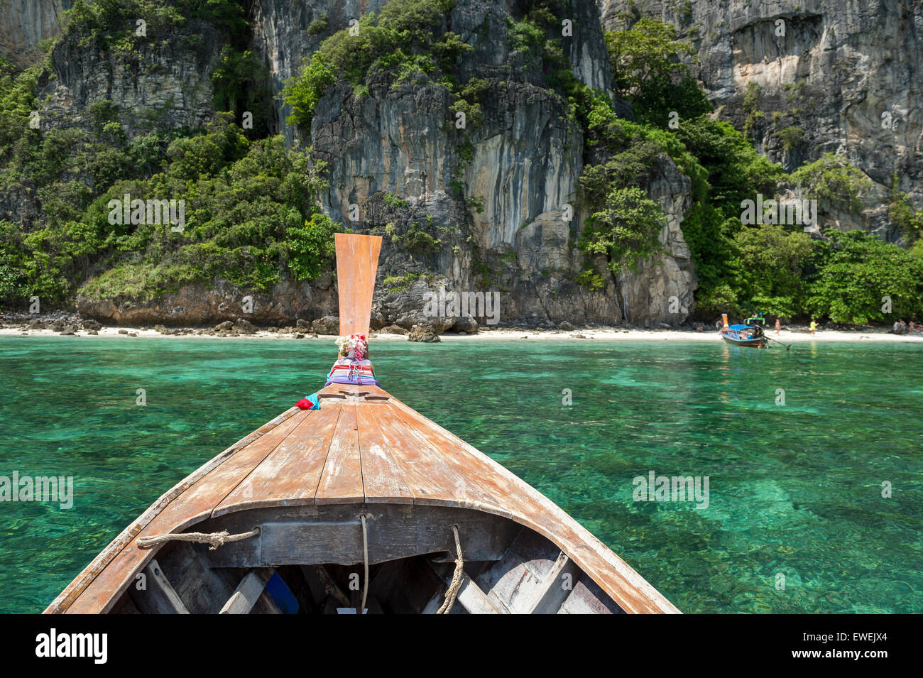 Dramatic karst mountain geology stands above the bow of a longtail boat on a day trip to Mosquito Island Krabi Thailand Stock Photo