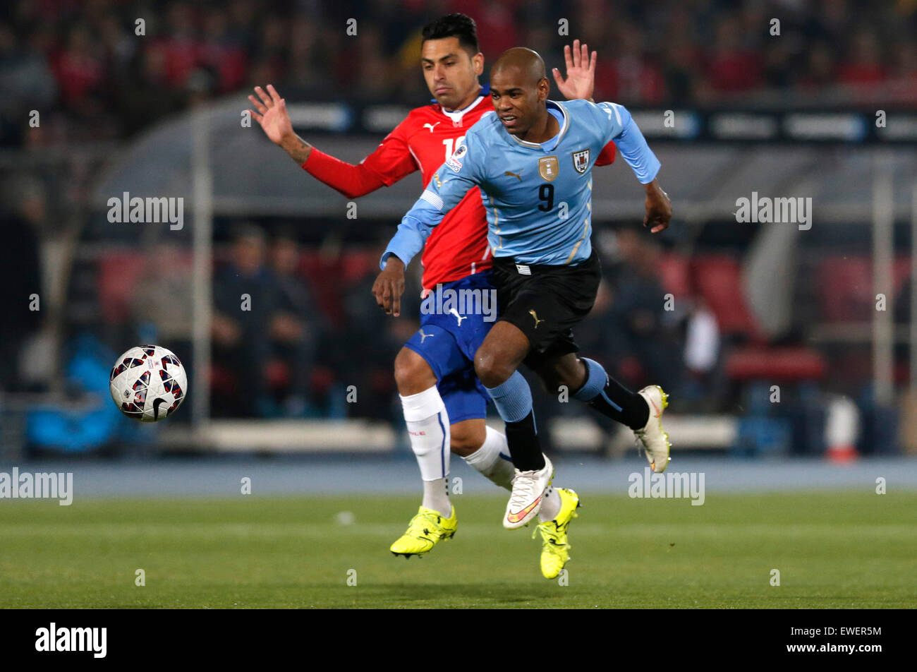 Santiago, Chile. 24th June, 2015. Gonzalo Jara (Rear) of Chile vies with Gonzalo Jara of Uruguay during their quarterfinal at 2015 Copa America in Santiago, Chile, on June 24, 2015. Credit:  Jorge Villegas/Xinhua/Alamy Live News Stock Photo