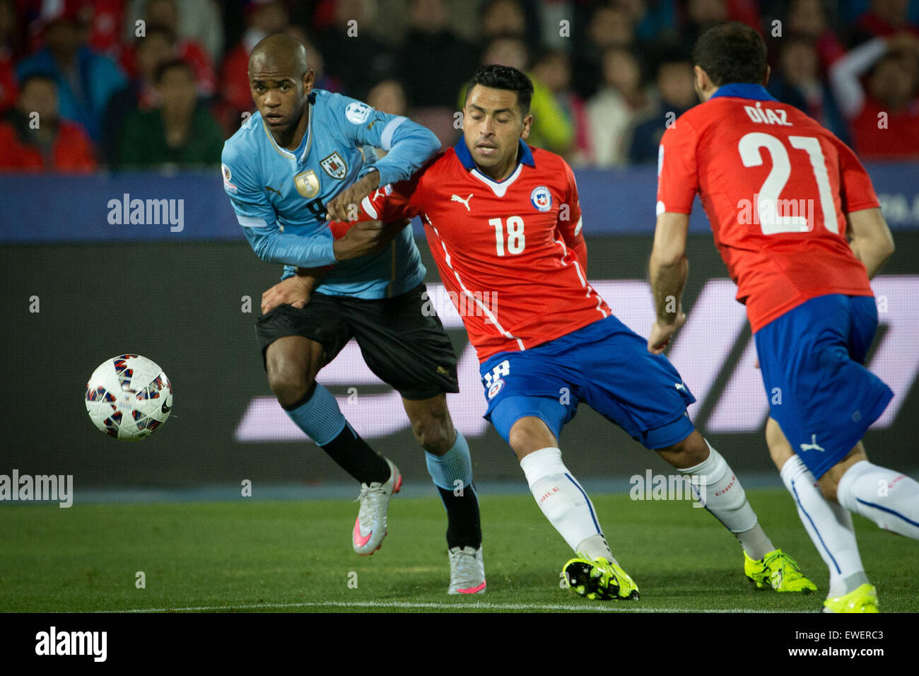 Santiago, Chile. 24th June, 2015. Gonzalo Jara (C) of Chile vies with Diego Rolan (L) of Uruguay during their quarterfinal at 2015 Copa America in Santiago, Chile, on June 24, 2015. Chile won 1-0. Credit:  Pedro Mera/Xinhua/Alamy Live News Stock Photo