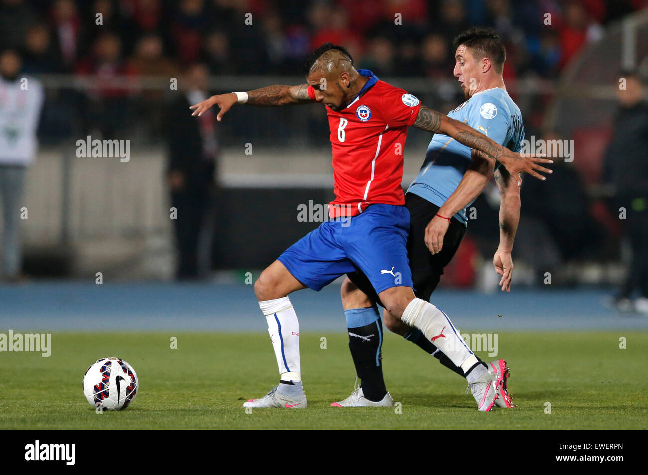 Santiago, Chile. 24th June, 2015. Arturo Vidal (L) of Chile vies with Cristian Rodriguez of Uruguay during their quarterfinal at 2015 Copa America in Santiago, Chile, on June 24, 2015. Chile won 1-0. Credit:  Jorge Villegas/Xinhua/Alamy Live News Stock Photo