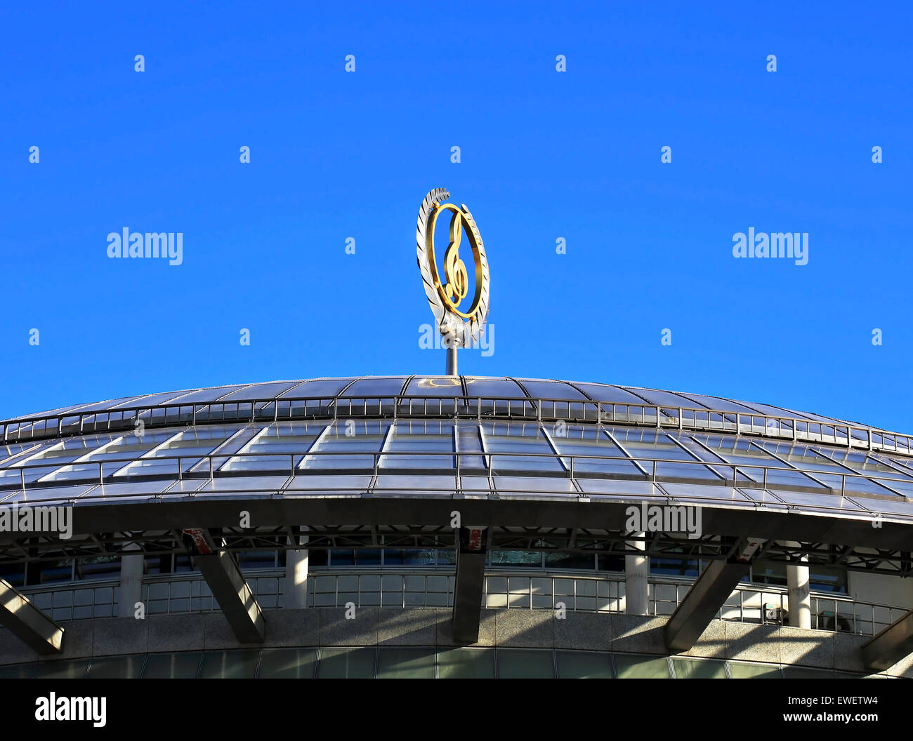 Metal dome of a modern building with a stylized golden treble clef ...