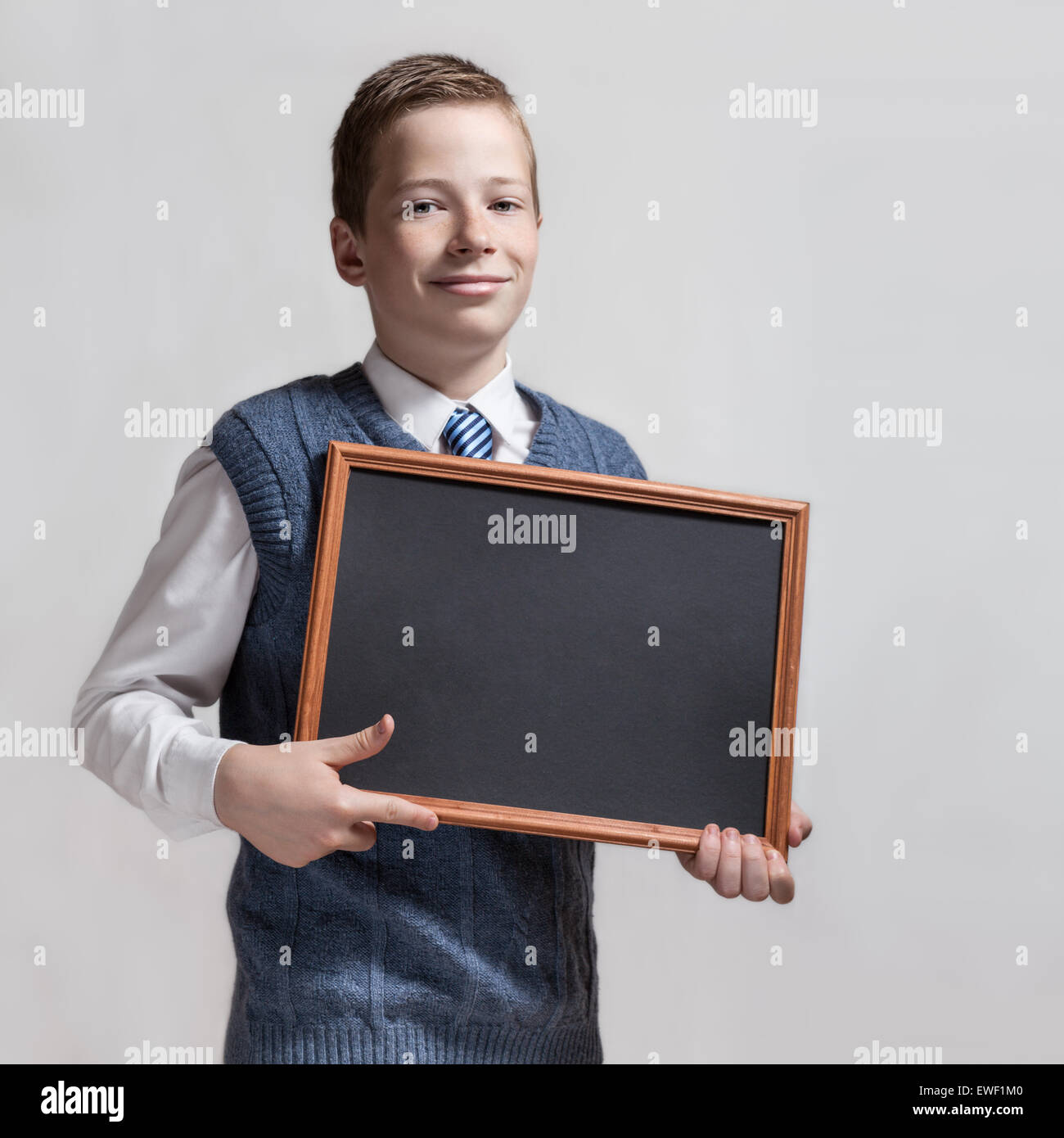 Cute schoolboy with empty chalkboard Stock Photo